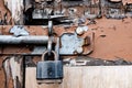 Detailed view of a padlock system seen attached to a heavily weathered wooden door. Royalty Free Stock Photo