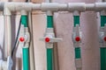 Close-up view of industrial plumbing system featuring green pipes and red valve handles, showcasing functionality and Royalty Free Stock Photo
