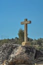 Detailed view at the stone crucifix sculpture, blue sky and field of trees on background