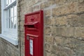 Detailed view of a vintage, red painted Royal Mail post box seen installed at the side of a private house. Royalty Free Stock Photo