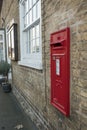 Detailed view of a vintage, red painted Royal Mail post box seen installed at the side of a private house. Royalty Free Stock Photo