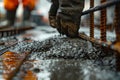 Detailed view of wet concrete being spread on a rebar framework, illustrating the foundational phase of construction and