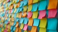 Detailed view of a whiteboard covered in colorful postit notes showcasing employee suggestions and feedback for