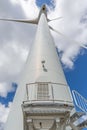 Detailed view of a wind turbine, with central tower pole, technical access stair and entrance door, generator, rotor and blade Royalty Free Stock Photo