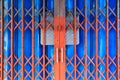 Detailed vintage red and blue painted textured metallic steel alloy door stretch of traditional Asian commercial building store Royalty Free Stock Photo