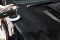 Detailer using a Rupes rotary machine on a luxury car