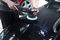 Detailer using a Rupes rotary machine on a luxury car