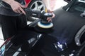 Detailer working with a Rupes rotary machine on a car panel