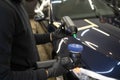 Detailing master applies car polish paste to the polisher. Vehicle paintwork polishing concept.