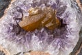 Details of an Amethyst geode with an embedded piece of brownish quartz crystal Royalty Free Stock Photo