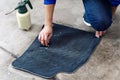 Details of automobile cleaning - male using professional chemical solutions to clean car floor mats