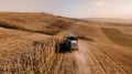 Details of autumn harvest. Aerial view of combine harvesting over the hills