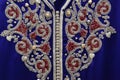 Details of a blue Moroccan caftan for women, and golden lace