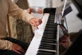 Children hands touching white and black piano keys while performing a musical composition, playing grand piano indoor Royalty Free Stock Photo