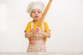 Details of children`s hands kneading dough. Cheerful cook child boy in a cap prepares burritos Royalty Free Stock Photo