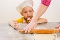 Details of children`s hands kneading dough. Cheerful cook child boy in a cap prepares burritos Royalty Free Stock Photo