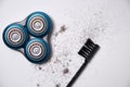 Details of a disassembled dirty shaver head and a cleaning brush on a light background. Soft selective focus. Copy space