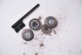 Details of a disassembled dirty shaver head and a cleaning brush on a light background. Soft selective focus. Copy space