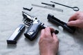 Details of the disassembled pistol. The hands of the master hold the frame of the pistol