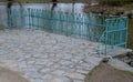 Details of the edge of the pond with paved banks flat stones. curved shape. the path is lined with weeping willows and the sluice Royalty Free Stock Photo