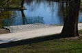Details of the edge of the pond with paved banks flat stones. curved shape. the path is lined with weeping willows and the sluice Royalty Free Stock Photo