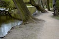 Details of the edge of the pond with paved banks flat stones. curved shape. the path is lined with weeping willows and the sluice Royalty Free Stock Photo