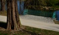 Details of the edge of the pond with paved banks flat stones. curved shape. the path is lined with weeping willows and the sluice Royalty Free Stock Photo