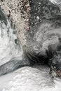 Inside of an ice cave with snow on the ground and rocks on top; end of a tunnel in Matanuska Glacier, Alaska. Royalty Free Stock Photo