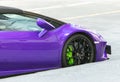 The details and front wheel of a purple lamborghini sportcar parked on the side of the street. concept photo supercars