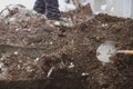 Details of a gravedigger covering a tomb with dirt with a shovel during a burial ceremony on a cold and snowy winter day Royalty Free Stock Photo