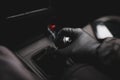 Details with the hand of a driver, in a latex glove, on an old and broken gear shift knob of a manual gearbox car during the Covid Royalty Free Stock Photo