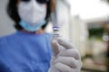 Details with the hand of a medical worker holding a dose of the Pfizer BioNTech Comirnaty anti Covid 19 vaccine at a drive thru