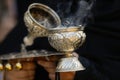 Details with the hand of a orthodox Christian nun holding a smoking metallic censer