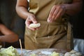 Details: hands of a housewife sprinkling flour on a wooden board while hands-on dumplings, cooking homemade varenyky