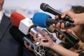 Details with the hands of journalists holding microphones in fron of a politician during a press conference