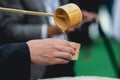 Details with the hands of a man pouring traditional Japanese sake in a wooden cup Royalty Free Stock Photo