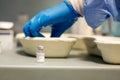 Details with the hands of a medical worker preparing a dose of the Pfizer BioNTech anti COvid 19 vaccine