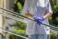 Details with the hands of a woman medic leaning patiently on a metal rail