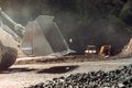 Close up details heavy construction machinery in open pit ore mine - wheel loader transports gravel at sorting plant Royalty Free Stock Photo