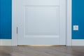 Details in the interior. Laminated parquet floors immitating oak texture, white baseboard, white door. Royalty Free Stock Photo