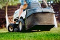 Details of landscaping and gardening. Worker riding industrial lawnmower Royalty Free Stock Photo