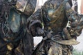 Details of Living statue of two pirates. Woman and man dressed in bronze costumes with hats and weapons pose as a realistic human