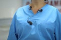 Details with many lavalier microphones on the medical coat of a woman medic