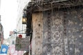 Details of a medieval building with sign and lantern. House with thatched roof and plastered walls with a pattern. Rose logo. Hist