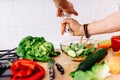 Details of mens hands adding salt and pepper to salad. perfect cook preparing salad for healthy life