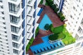 Details of modern building exterior - patio in high-rise building with swimming pool, lounge zone, green trees. Royalty Free Stock Photo