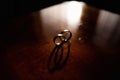 Details of the morning of the wedding day. Two gold wedding rings are on the brown wood table Royalty Free Stock Photo