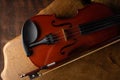 Details of an old and beautiful violin on a rustic wooden surface and black background, low key portrait, selective focus Royalty Free Stock Photo