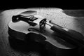 Details of an old and beautiful violin on a rustic wooden surface and black background, low key portrait, selective focus Royalty Free Stock Photo