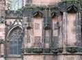 Details of ornately carved medieval stonework with niches and faces on the facade of chester cathedral